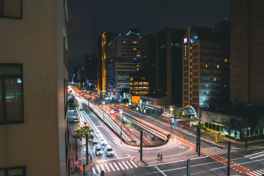 Dynamic night view of São Paulo with bustling traffic and illuminated buildings.