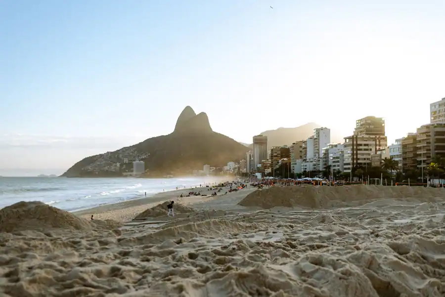 Sunny day at Ipanema Beach with view of mountains and cityscape in Rio de Janeiro.