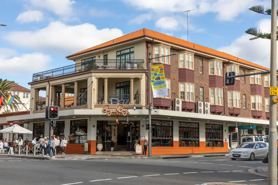 Busy corner view of Coogee Bay Hotel in Sydney with people, cars, and vibrant street life.